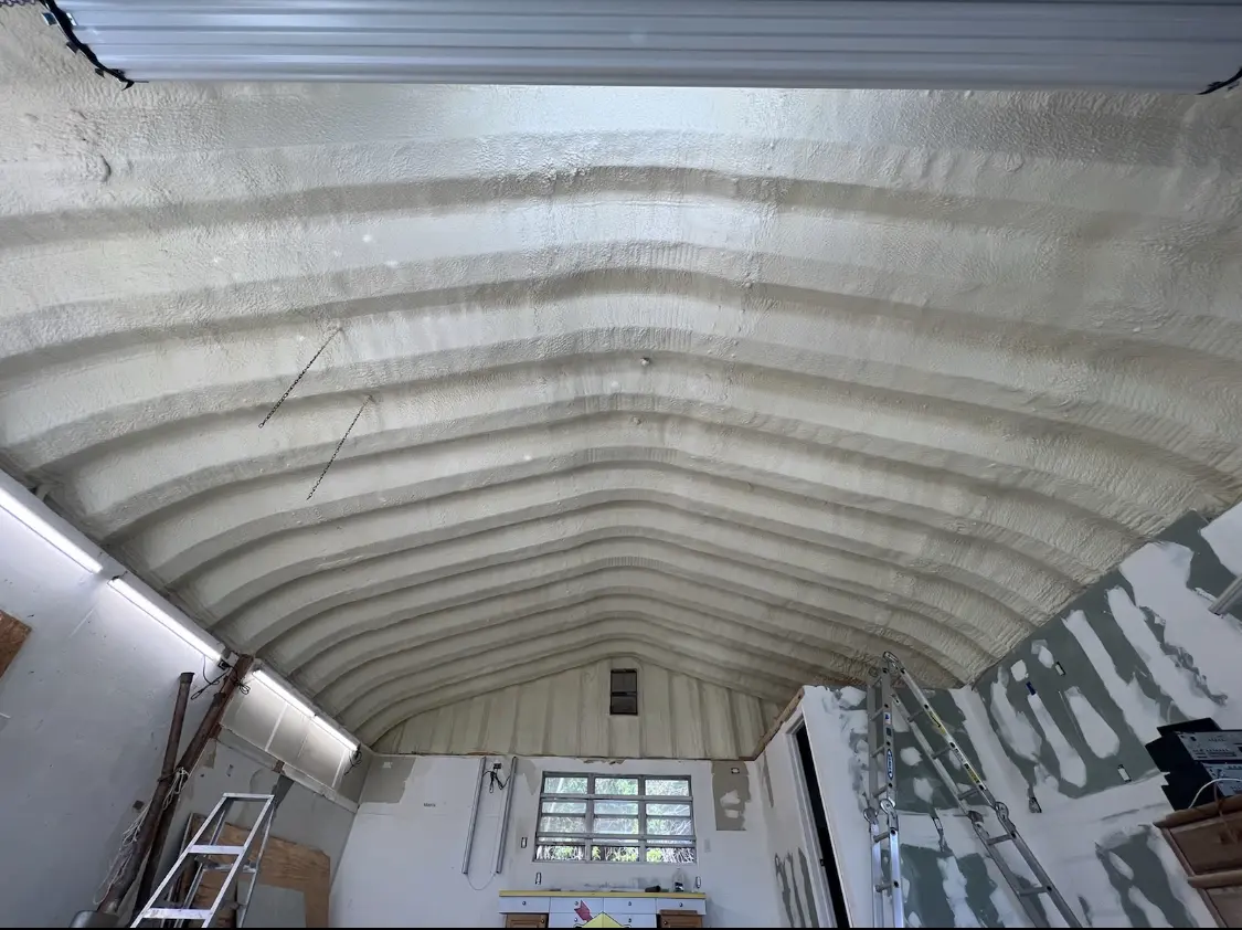 Spray polyurethane foam applied to the underside of a metal roof deck in Artesia